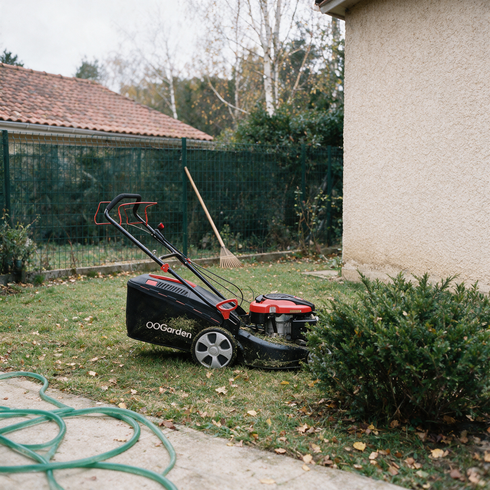 Tondeuse thermique tractée OOGarden T51T-196AML garée sur une pelouse d’automne, avant le contrôle de sa traction